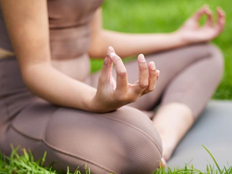 Start your day the calm way. Closeup shot of an unrecognisable woman meditating outdoors