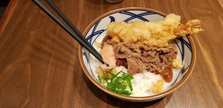 Japanese traditional food beef teriyaki with stickt rice and tempura shrimp sliced spring onion in a bowl