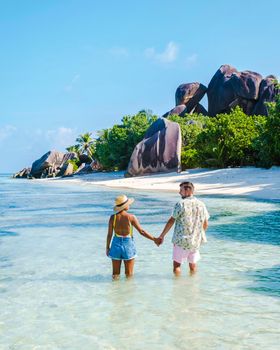 Anse Source d'Argent, La Digue Seychelles, a young couple of Caucasian men and Asian women on a tropical beach during a luxury vacation in Anse Source d'Argent, La Digue Seychelles