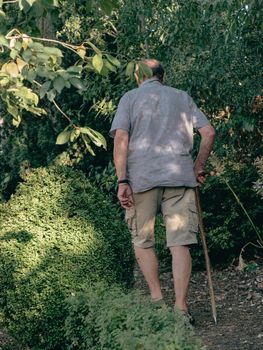 old man with sky pole walking around in garden and farm in summer season