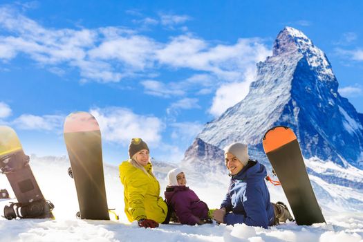 family and snowboard on snowy mountain.