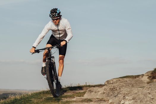 Professional Male Cyclist Riding Bike, Adult Equipped Man on Bicycle on Top of Hill, Copy Space on the Sky Background