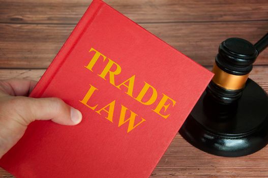 Trade law text on law book with judge gavel on wooden desk background. Law concept