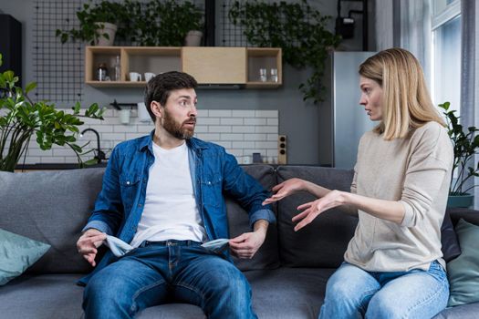 A young woman demands money from her husband, the man does not show empty pockets. At home, sitting on the couch. Quarrels, conflicts, misunderstandings. Money crisis