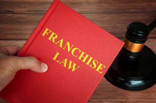 Franchise law text on law book with judge gavel on wooden desk background. Law concept
