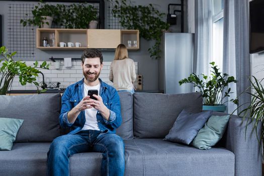 man has a secret communication correspondence with his mistress, sitting on the couch at home