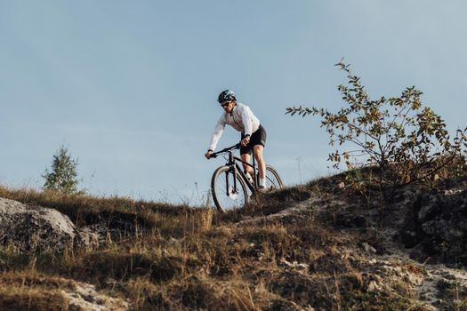 Equipped Professional Cyclist Descends a Slope on Mountain Bike, Sportsman Going Down from Hill on Bicycle