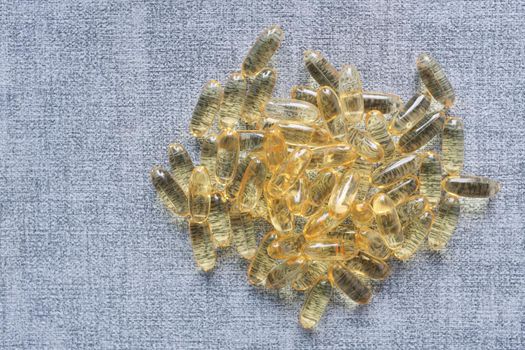 fish oil supplement on orange background .
