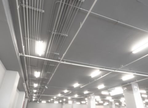 Tidy installation of Galvanized Electrical Metallic Tubing (EMT) Conduits on the ceiling of parking building