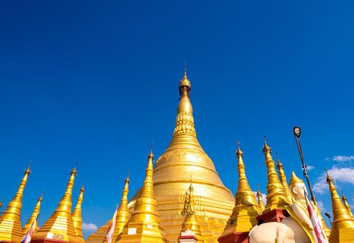 A group of golden pagodas under the blue sky of Myanmar