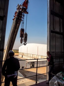 Hoist of crane at the window of industrial plant