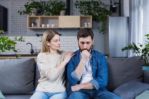 A woman supports an upset husband who has failed, a married couple sitting on the couch