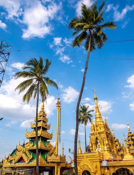 Group of golden pagoda and square hall with a pyramidal roof castle mondop and tiered umbrella Burmese style under the blue sky