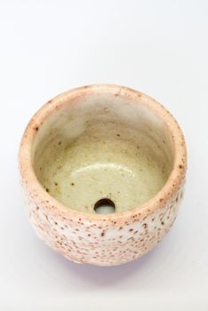 The ceramic cup has been adapted for planting small pot plants