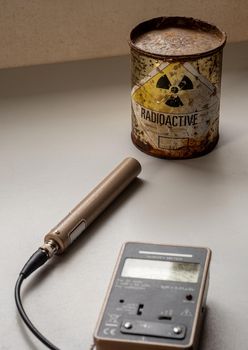 Hand-held radiation survey instrument detecting on radioactive material in the package. Ionizing radiation hazard symbol on package