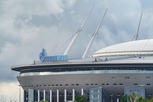 Russia, St. Petersburg, 29 July 2022: The new building of football stadium Gazprom Arena, the sliding metal roof glitters with spires in the sun, the gas company Gazprom. High quality photo