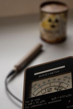 Hand-held radiation survey instrument detecting on radioactive material in the package. Ionizing radiation hazard symbol on package