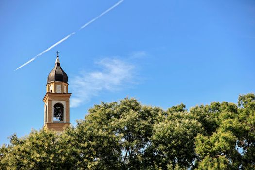 Church bell tower in the trees in Rovigo, Italy