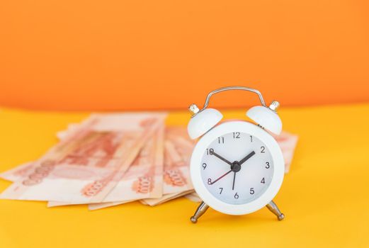 Time value of money concept, analog clock on US dollar banknote, depicting receiving money today can be poised to increase the future value by investing