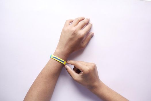Hand with blue and yellow wristband , colors of flag of Ukraine