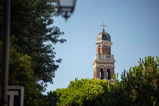 Church bell tower in the trees in Rovigo, Italy