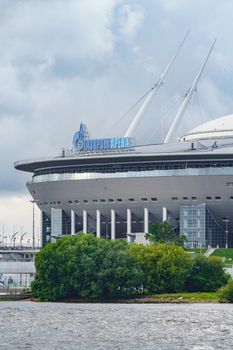 Russia, St. Petersburg, 29 July 2022: The new building of football stadium Gazprom Arena, the sliding metal roof glitters with spires in the sun, the gas company Gazprom. High quality photo