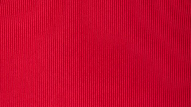 Bright red saturated background in volumetric strip fabric textile. High quality photo