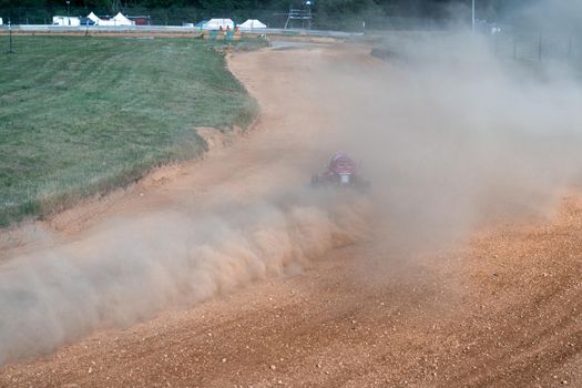 buggies on the autocross track, skidding, dust and dirt flying under the tires.