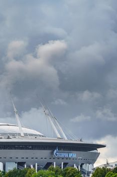Russia, St. Petersburg, 29 July 2022: The new building of football stadium Gazprom Arena, the sliding metal roof glitters with spires in the sun, the gas company Gazprom. High quality photo