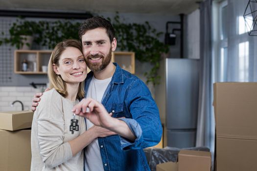 Close-up portrait of a young family, happy bought a new apartment, holding the keys to the house, happy