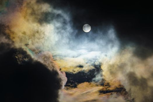 Diffraction of light on drops of supercooled water in clouds, rainbow clouds against the blue sky in clear sunny weather, irisation of cumulus clouds, optical phenomenon, spectral colors. High quality photo