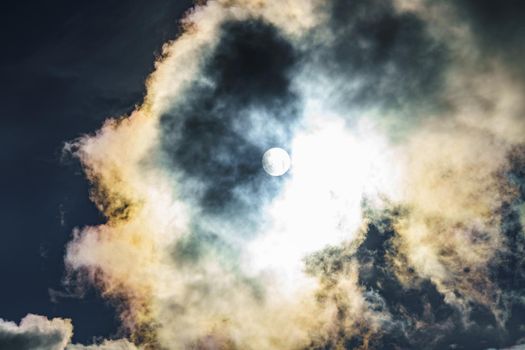 Diffraction of light on drops of supercooled water in clouds, rainbow clouds against the blue sky in clear sunny weather, irisation of cumulus clouds, optical phenomenon, spectral colors. High quality photo
