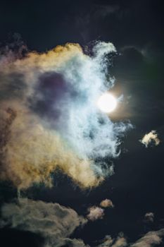 Diffraction of light on drops of supercooled water in clouds, rainbow clouds against the blue sky in clear sunny weather, irisation of cumulus clouds, optical phenomenon, spectral colors. High quality photo