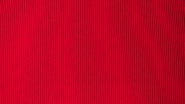 Bright red saturated background in volumetric strip fabric textile. High quality photo