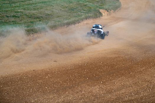 buggies on the autocross track, skidding, dust and dirt flying under the tires.