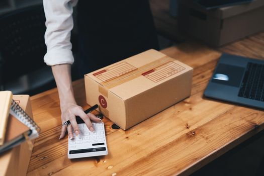 Business entrepreneur use calculator with laptop on his desk