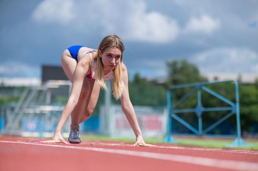 Female runner in the stadium is ready to race