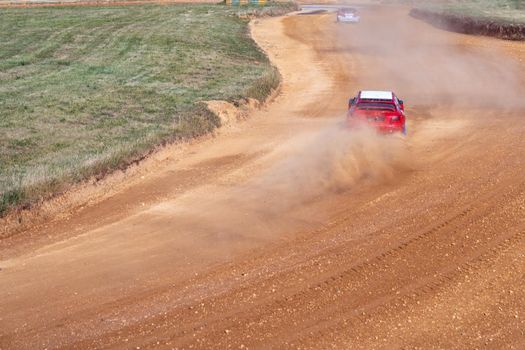 gran turismo races on the autocross track, skidding, dust and dirt from under the tires.