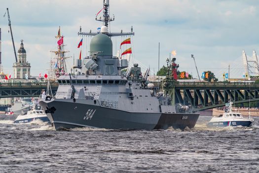 Russia, St. Petersburg, 28 July 2022: A warship goes along the Neva River under open bridges at the time of the rehearsal of the celebration of the day of the Navy in sunny weather. High quality photo
