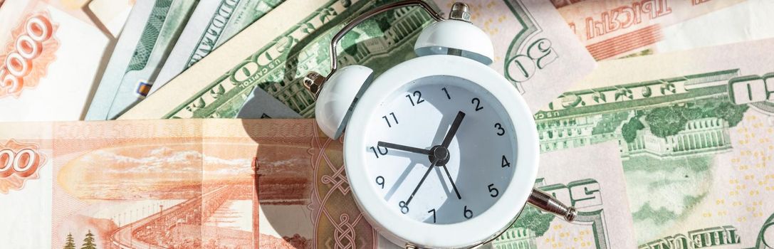 Time value of money concept, analog clock on US dollar banknote, depicting receiving money today can be poised to increase the future value by investing