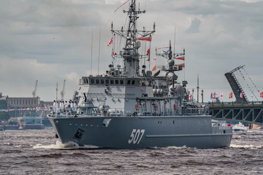 Russia, St. Petersburg, 28 July 2022: A lot of warships goes along the Neva River under open bridges at the time of the rehearsal of the celebration of the day of the Navy in sunny weather. High quality photo