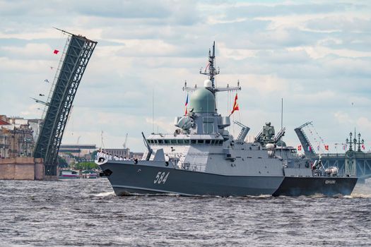 Russia, St. Petersburg, 28 July 2022: A lot of warships goes along the Neva River under open bridges at the time of the rehearsal of the celebration of the day of the Navy in sunny weather. High quality photo