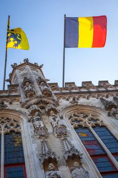 Belgian flags in Town hall, flemish architecture in Bruges at sunny day, Belgium