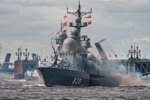 Russia, St. Petersburg, 28 July 2022: A lot of warships goes along the Neva River under open bridges at the time of the rehearsal of the celebration of the day of the Navy in sunny weather. High quality photo