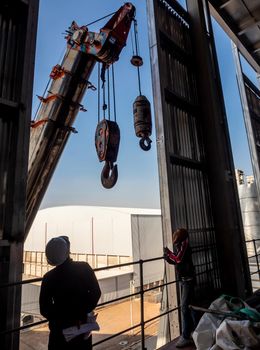 Hoist of crane at the window of industrial plant