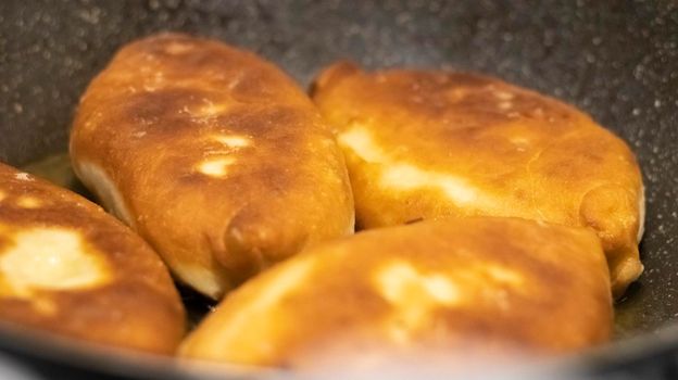 Appetizing savory fried pies. Traditional fresh, freshly made homemade stuffed pies, also known as pastel. Rustic fried yeast dough pies