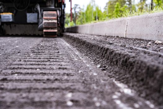 a close-up of the asphalt cut on the road made by a cold cutter during road works. Removed layer of old asphalt during road repairs. Tractor Machine Cold Milling Cutter