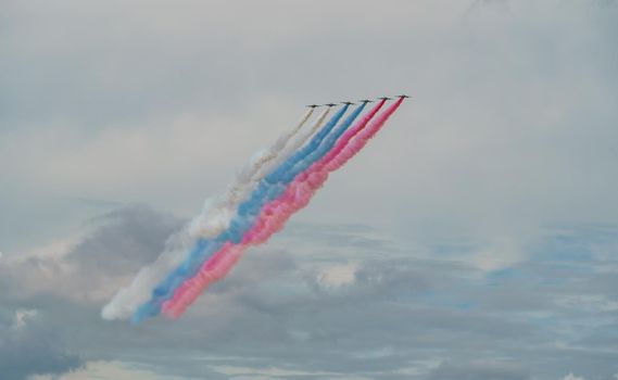 Russian Air Force planes paint the colors of the Russian flag in the sky on St. Petersburg during the celebration of the Day of the Navy. High quality photo