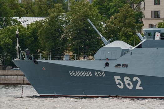 Russia, St. Petersburg, 28 July 2022: A several modern warships anchored at the Neva River embankment during the Navy Day celebrations in sunny weather, sailors on deck in festive uniforms. High quality photo