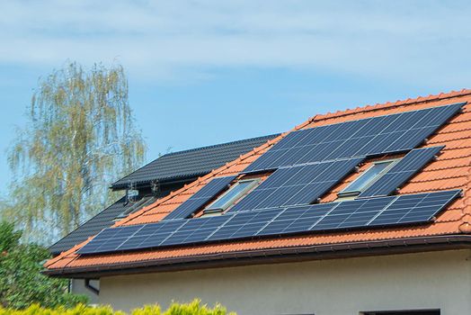 House roof with photovoltaic modules. Historic farm house with modern solar panels on roof and wall High quality photo